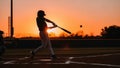 Dynamic Baseball Player Hitting Ball at Sunset Golden Hour Silhouette Action on the Field Royalty Free Stock Photo