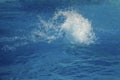 Powerful splash on a blue water surface with waves and splashes