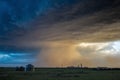 A powerful storm blows dust clouds over farmland with the setting sun illuminating. Royalty Free Stock Photo