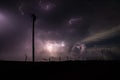 A powerful storm fills the sky with lightning bolts, behind the silhouette of power lines.