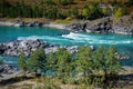 Powerful stream of water, rocky shores overgrown with grass and trees. Turquoise mountain river on sunny autumn day. Magnificent Royalty Free Stock Photo