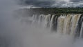 The powerful streams of the waterfall collapse from the cliff ledge into the abyss Royalty Free Stock Photo