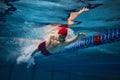 Powerful strokes. Freestyle swimming type. Young man, swimmer in motion training in swimming pool Royalty Free Stock Photo