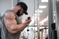 powerful strong active guy with beard lifting heavy weight in gym listen music with wireless earpieces