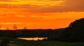 powerful sunset in red, yellow and golden light. Meadow in the foreground