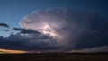 Powerful supercell thunderstorm unleashing lightning over vast plains at sunset, creating a dramatic and intense weather Royalty Free Stock Photo