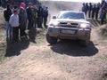 Powerful SUV overcome a rocky slope at the races the crowd of people, the audience watching the spectacle