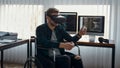 Powerful tool. Portrait of young male web developer in a wheelchair wearing virtual reality headset while working in the