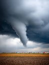 Powerful tornado funnel against a dramatic sky in the countryside. Royalty Free Stock Photo