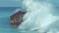 Powerful turquoise ocean wave splashes across a big rock in the middle of sea Royalty Free Stock Photo