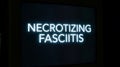 Necrotizing fasciitis text glows ominously against dark backdrop for medical education resources Royalty Free Stock Photo