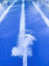 A powerful water jet filling an olympic swimming pool with white lane lines in the bottom Royalty Free Stock Photo