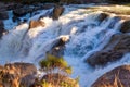 Waterfall cascading over rocks, catching last rays of light Royalty Free Stock Photo