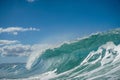 Powerful wave crashing against the crystal blue ocean surface