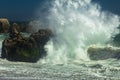 Powerful wave crashing on the rocks at a beach in Malibu