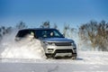 Powerful 4x4 offroader car running on snow field