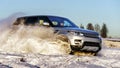 Powerful 4x4 offroader car running on snow field