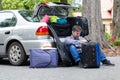 Powerless father next to car trunk