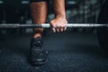 Powerlifter prepares for deadlift a barbell in gym