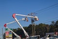 Powerline workers in lift buckets working on power lines