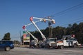 Powerline workers in lift buckets working on power pole lines