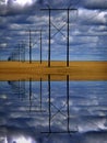 Powerlines in Field with Blue Sky and Clouds Reflection in Water Royalty Free Stock Photo