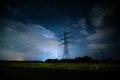 Powerlines in front of a Thunderstorm over a field Royalty Free Stock Photo