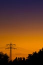 Powerpole in orange purple sunset light Royalty Free Stock Photo