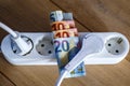 Powerstrip, plugs and Euro banknotes to illustrate the rise of the electricity and daily life expenses Royalty Free Stock Photo