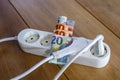 Powerstrip, plugs and Euro banknotes to illustrate the rise of the electricity and daily life expenses Royalty Free Stock Photo