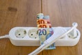 Powerstrip, plugs and Euro banknotes to illustrate the rise of the electricity and daily life expenses Royalty Free Stock Photo