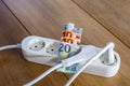 Powerstrip, plugs and Euro banknotes to illustrate the rise of the electricity and daily life expenses Royalty Free Stock Photo