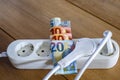 Powerstrip, plugs and Euro banknotes to illustrate the rise of the electricity and daily life expenses Royalty Free Stock Photo