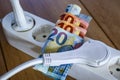 Powerstrip, plugs and Euro banknotes to illustrate the rise of the electricity and daily life expenses Royalty Free Stock Photo