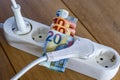 Powerstrip, plugs and Euro banknotes to illustrate the rise of the electricity and daily life expenses Royalty Free Stock Photo