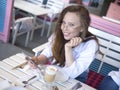 Pozitive smiling blogger woman sitting at a cafe. Royalty Free Stock Photo