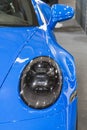 Poznan, Poland - April 08, 2022: Poznan Motor Show. Front lamp of blue Porsche 911. Detail and part of vehicle
