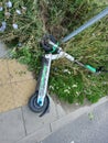 Poznan, Poland - August 4th 2023: Broken scooter lying on a sidewalk