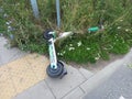 Poznan, Poland - August 4th 2023: Broken scooter lying on a sidewalk