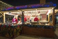 Two saleswomen in a Christmas kiosk with selling hot food. Christmas market in Poznan. Poland Royalty Free Stock Photo