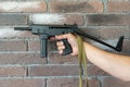 PP-91 Kedr submachine gun. A man holds a machine gun in his hand on the background of a brown brick wall