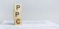 PPC - Pay Per Click acronym, wooden blocks, business concept, gray background