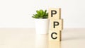 PPC - pay per click - acronym on wooden cubes on wooden backround. business concept