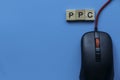 PPC Pay Per Click with alphabet and mouse on blue background Royalty Free Stock Photo