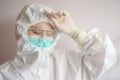 Nurse having headache and tired from work while wearing PPE suit for protect coronavirus disease. Royalty Free Stock Photo