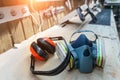 PPE respirator face half mask and ear protection equipment on wooden workbench of carpentry professional woodwork workshop. Worker