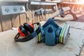PPE respirator face half mask and ear protection equipment on wooden workbench of carpentry professional woodwork workshop. Worker