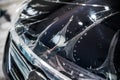 PPF installation process, close-up on transparent film and bubble on a front headlight and hood with Car wrapping specialist. Royalty Free Stock Photo