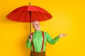 Pphoto of senior man happy positive smile protect rain umbrella fall isolated over yellow color background