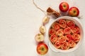 ÃÂpple pie in the baking dish decorated with fresh sliced apples and cinnamon sticks. Vegetarian tart on the white background Royalty Free Stock Photo